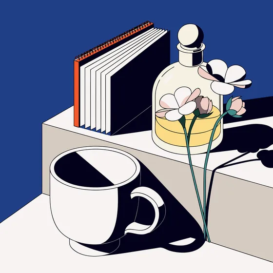 A notebook, a cup and flowers on a desk
